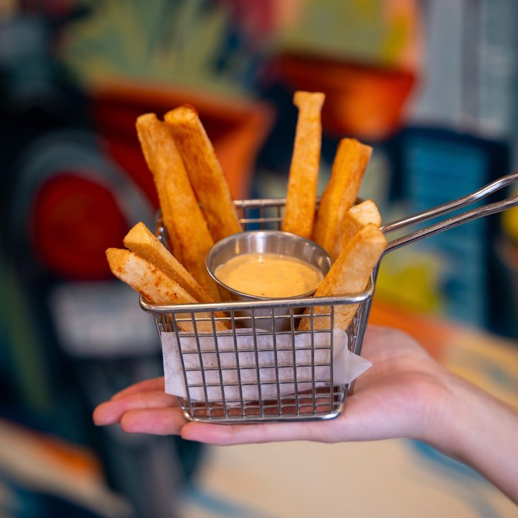 Crispy cassava fries in a basket with garlic mayo