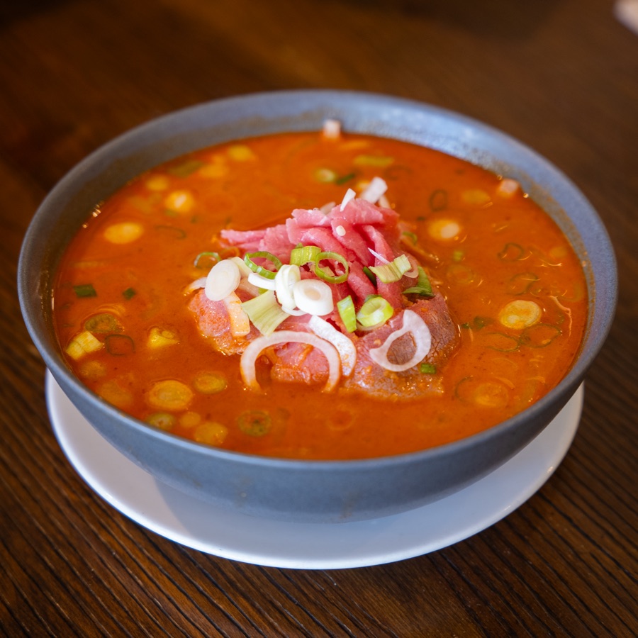 Satay noodle soup topped with rare beef, scallions and pickled onion