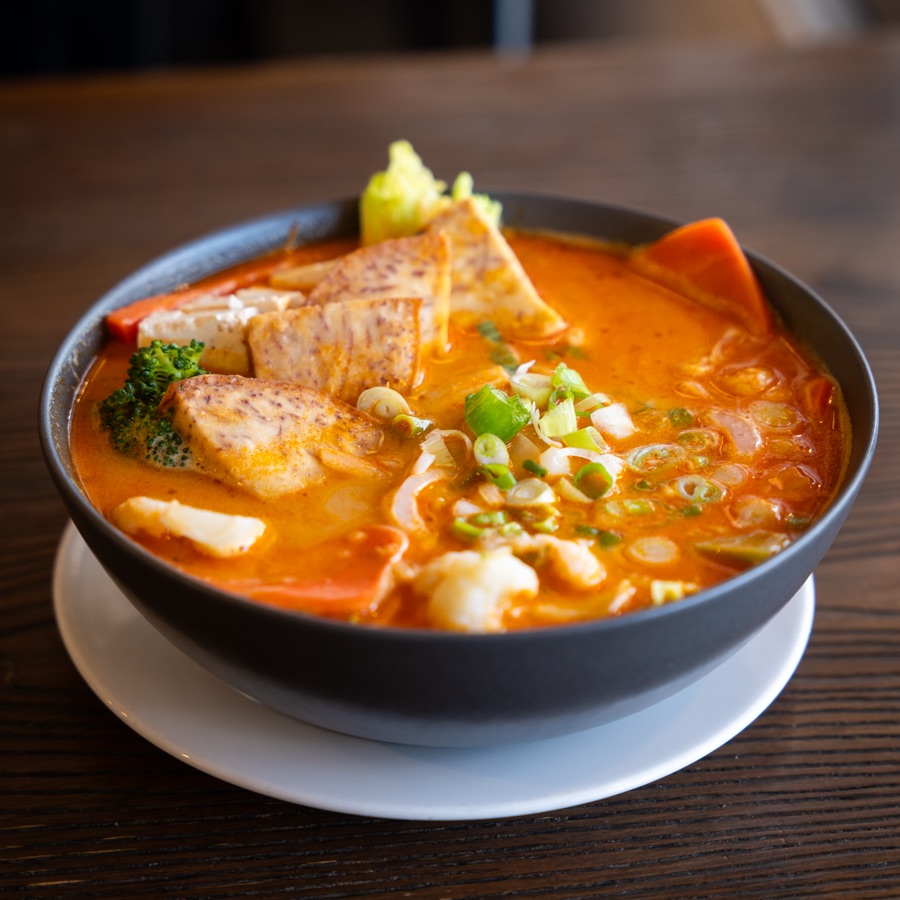 Vegan satay noodle soup with tofu, taro and vegetables in coconut satay broth
